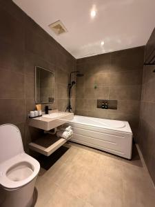 a bathroom with a tub and a toilet and a sink at YourHome - Stay & More in Hoàng Mai +110 photos