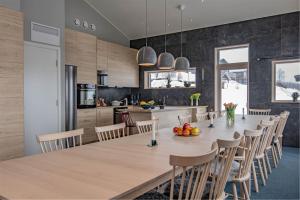 a kitchen and dining room with a large wooden table and chairs at Hemavan Mountain Lodge Storfjället in Hemavan