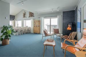 a waiting room with chairs and a table and a fireplace at Hemavan Mountain Lodge Storfjället in Hemavan +30 photos