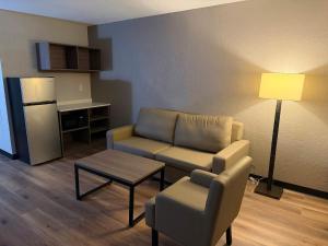 a living room with a couch and a chair and a table at Red Roof Inn Kokomo in Kokomo