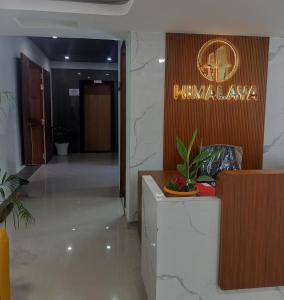 a lobby of a hotel with a sign on the wall at Ganges Abode in Haridwār