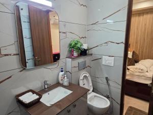 a bathroom with a sink and a toilet and a mirror at Ganges Abode in Haridwār +5 photos