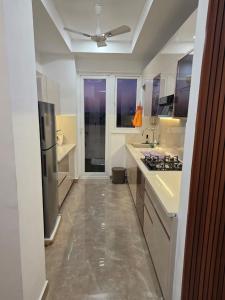 a large kitchen with a refrigerator and a sink at Ganges Abode in Haridwār