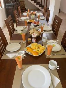 a long table with plates of food and orange juice at Neue Villa Wunderschön in Bentota