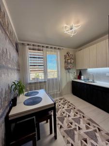 a kitchen with a table and a sink in it at 7 Apartmens ЖК 7-Небо Аквапарк Промринок 7 in Odesa