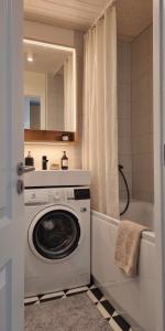 a bathroom with a washing machine and a bath tub at Hiiu korter Kärdlas in Kärdla