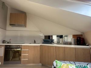 an attic kitchen with wooden cabinets and a stove at Ático La Quinta Esencia in Negreira