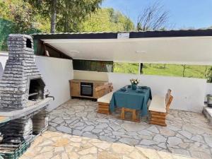 a patio with a table and a stone fireplace at Residence La Femme in Tuzla