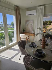 a dining room with a table and chairs and windows at Mullins Townhouse in Saint Peter