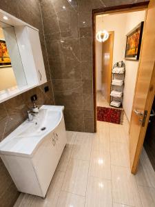 a bathroom with a white sink and a shower at Versailles Rooms in Dukati i Ri +48 photos