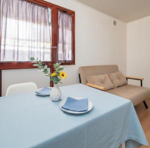 a table with a blue table cloth and a couch at Camping 4 Cerchi Ecogreen in Lido di Fermo +15 photos