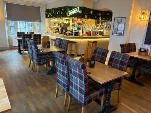 a restaurant with wooden tables and chairs and a bar at The Swan Hotel in Kington +6 photos