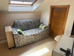 a small living room with a couch in front of a door at Ático La Quinta Esencia in Negreira +10 photos