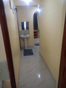 a small bathroom with a sink and a toilet at Kibwezi Penthouse in Libwezi