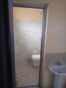 a bathroom with a toilet and a sink at Kibwezi Penthouse in Libwezi