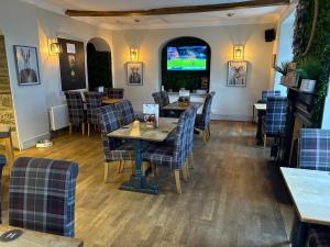 a restaurant with tables and chairs and a television at The Swan Hotel in Kington