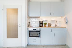 a white kitchen with white cabinets and a stove at Marina Wendtorf Kajüte in Wendtorf