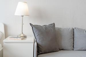 a lamp on a table next to a couch with pillows at Marina Wendtorf Kajüte in Wendtorf +21 photos