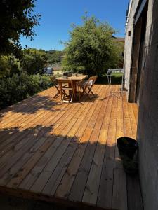 a wooden deck with a table and chairs on it at Rez-de-villa 65m2 climatisé in Propriano
