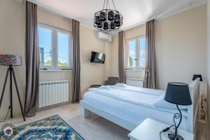 a bedroom with a bed and a chandelier at Vila Eleonora Beograd in Belgrade +100 photos