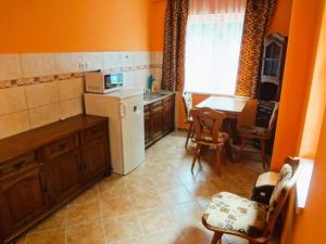a kitchen with a white refrigerator and a table at Horváth Apartmanház in Orosháza