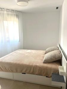 a white bedroom with a bed and a window at Marina Luxury in Torrevieja +12 photos