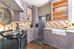 a kitchen with purple cabinets and a black stove at Warwick Centre Townhouse Castle views in Warwick