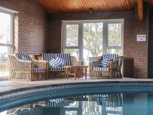 a group of chairs and a table next to a pool at Starlight Sanctuary in Malton
