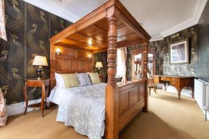 a bedroom with a canopy bed and a piano at Warwick Centre Townhouse Castle views in Warwick