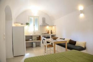 a kitchen and living room with a table and a refrigerator at Vasiliki guesthouse in Aroniadika