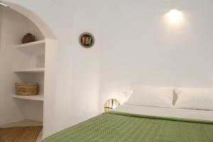 a bedroom with a bed with a clock on the wall at Vasiliki guesthouse in Aroniadika