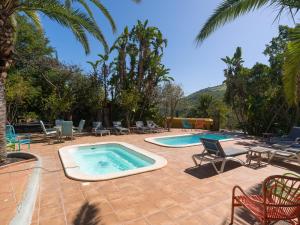 a patio with a swimming pool and chairs and palm trees at Rustic Home By CanariasGetaway in Telde