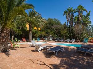 a swimming pool with lounge chairs and palm trees at Rustic Home By CanariasGetaway in Telde
