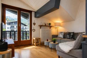 a living room with a couch and a large window at Superbe T3 en face du Brevent, Chamonix in Chamonix +9 photos