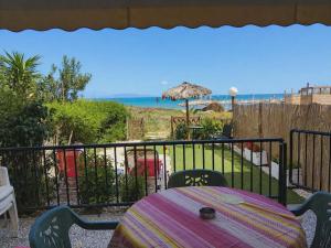 a table on a balcony with a view of the ocean at ON THE SAND apartment in Artemida