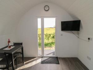a room with a table and a clock on a wall at Natures Nest in Malton
