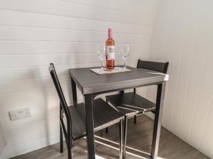 a table with a bottle of wine and two glasses at Natures Nest in Malton