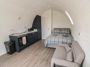 a bedroom with a bed and a couch and a sink at Natures Nest in Malton +23 photos