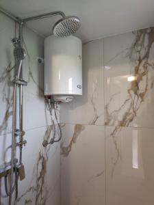 a bathroom with a shower with a shower head at Guest House Bee in Visoko +32 photos
