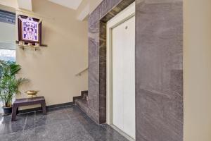 a hallway with a door and a bench and a table at Hotel O Maruthi Paradise Netaji Udyanavana Park in Bangalore