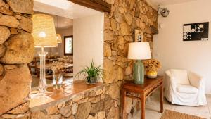 a living room with a stone wall at Salvacintoggio -Votre Villa avec Piscine Privée- in Porto-Vecchio