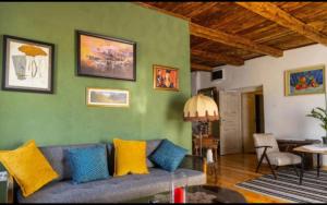 a living room with a blue couch and yellow pillows at Old House Piperi in Podgorica