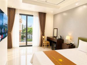 a hotel room with a bed and a desk and a window at Sunrise Airport Hotel Noi Bai in Noi Bai