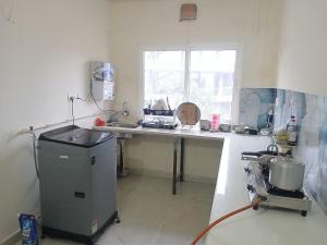 a kitchen with a counter and a sink and a window at O2 Homes in Guwahati