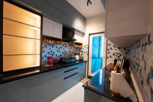 a kitchen with white cabinets and a black counter top at Dlite Rivera Premium Hotel Apartments in Bangalore