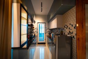 a kitchen with a refrigerator and a door at Dlite Rivera Premium Hotel Apartments in Bangalore +19 photos