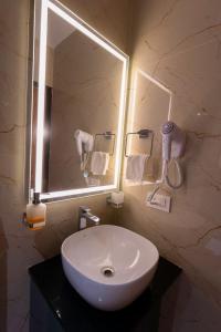 a bathroom with a white sink and a mirror at Dlite Rivera Premium Hotel Apartments in Bangalore