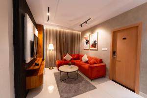 a living room with a red couch and a table at Dlite Rivera Premium Hotel Apartments in Bangalore