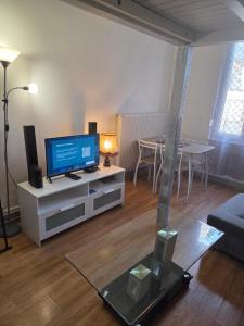 a living room with a tv and a table at Spacieux studio prestige in Bischheim