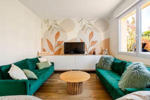 a living room with a green couch and a table at Grande maison familiale centre ville - 2km des plages in Beaussais sur Mer